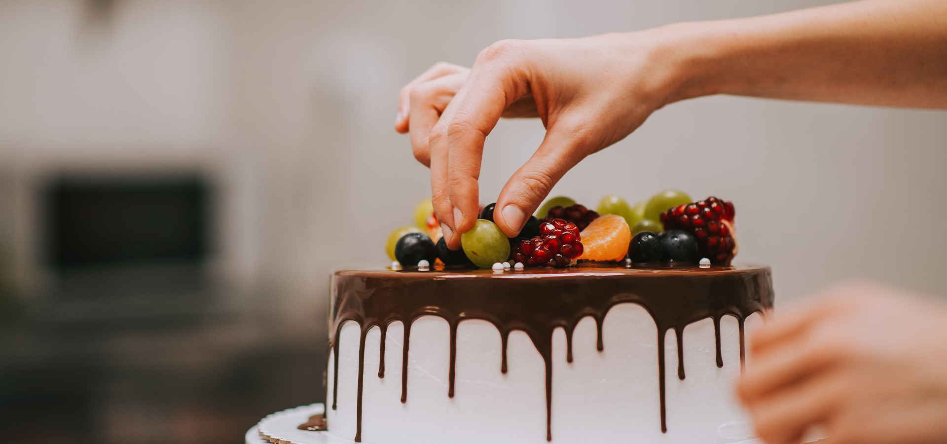 Nahaufnahme - Torte wird mit Früchten verziert