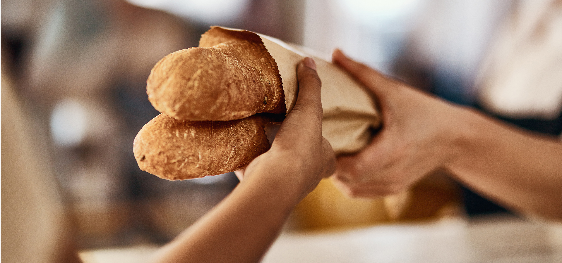 Nahaufnahme Übergabe von zwei Baguette