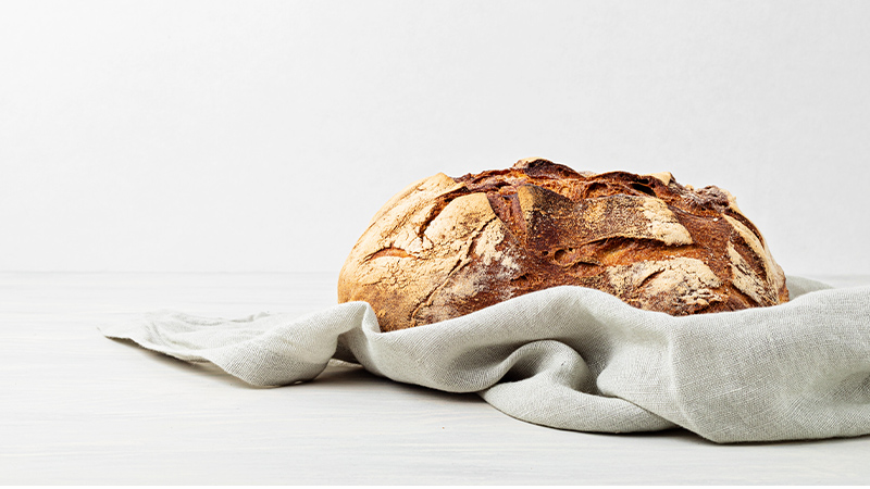 Brot auf weißem Hintergrund in Tuch gehüllt